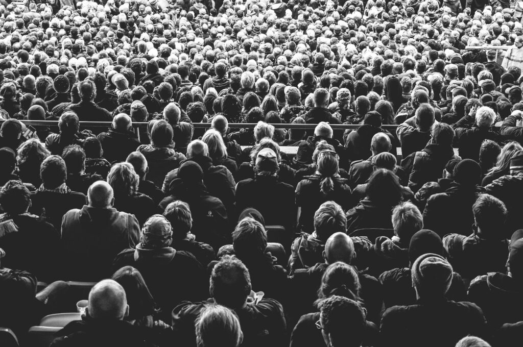 grayscale photo of people sitting on chair