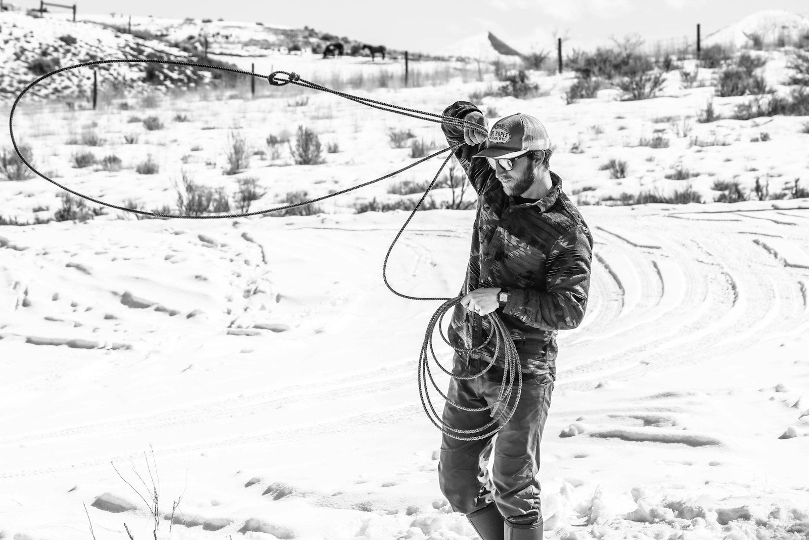 man in black jacket and pants holding rope